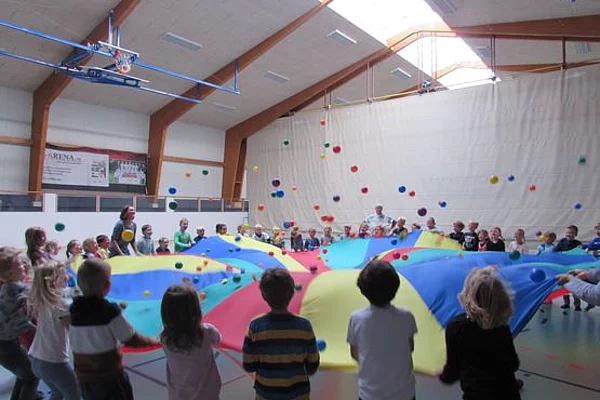 Im Rahmen des Projektes „Singen ohne Grenzen“ begegneten sich zum ersten Mal deutsche und dänische Kinder aus dem 1. und 2. Jahrgang in der Schule im Autal in Sieverstedt, hier beim gemeinsamen Spiel mit dem Fallschirm und den leichten bunten Bällen in der Sporthalle im September 2019